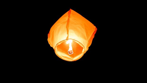 A balloon lantern floating up at night